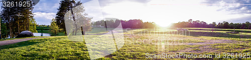 Image of Sunset over green farm field 