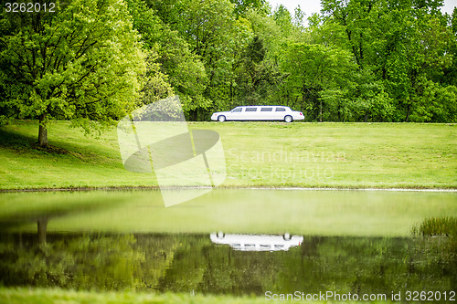 Image of white limo reflecting in lake