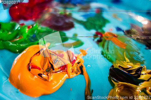 Image of mixed oil paints on pallet with various colors