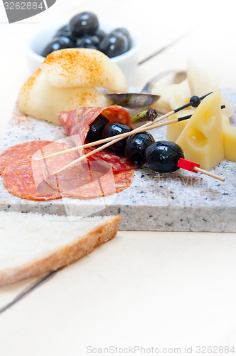 Image of mix cold cut on a stone with fresh pears