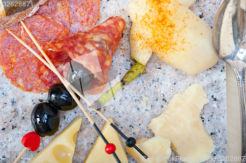 Image of mix cold cut on a stone with fresh pears