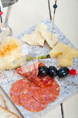 Image of mix cold cut on a stone with fresh pears