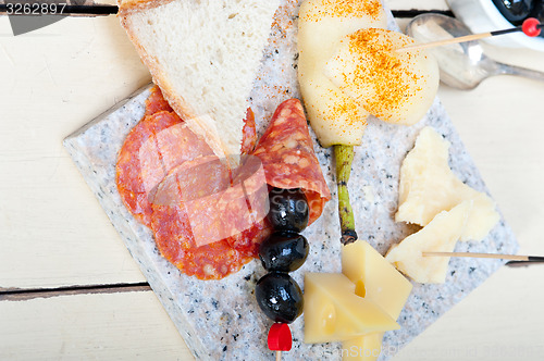 Image of mix cold cut on a stone with fresh pears