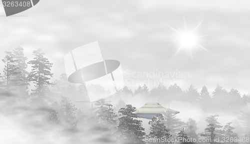 Image of UFO in a landscape of misty forest at sunrise