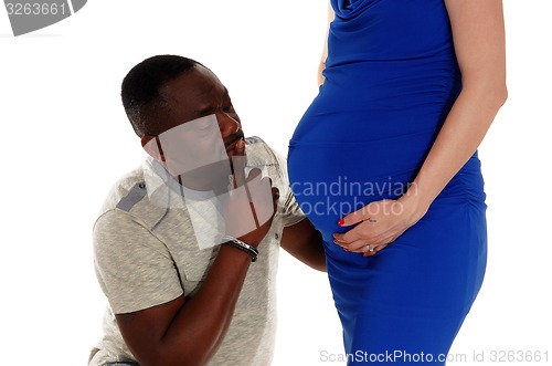 Image of Black man wondering baby belly.