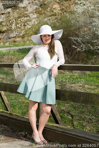 Image of Cheerful fashionable woman in stylish hat and frock posing