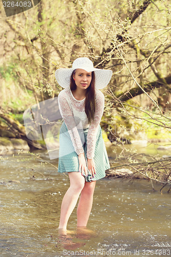 Image of Cheerful fashionable woman in stylish hat and frock posing