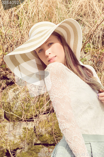 Image of Cheerful fashionable woman in stylish hat and frock posing