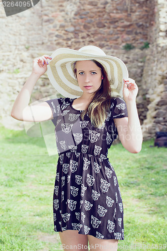 Image of Cheerful fashionable woman in stylish hat and frock posing