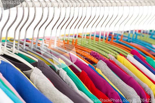 Image of Collection of colored shirts on steel hangers