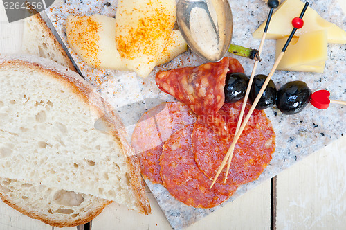 Image of mix cold cut on a stone with fresh pears