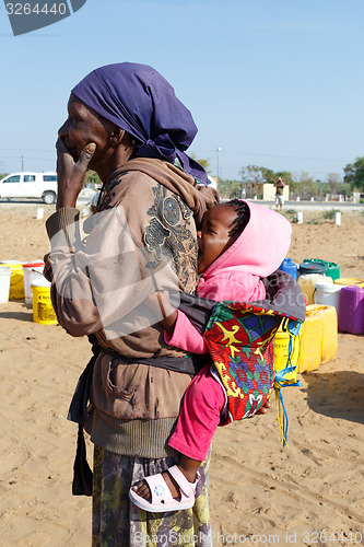 Image of small namibian child on the back of his mother