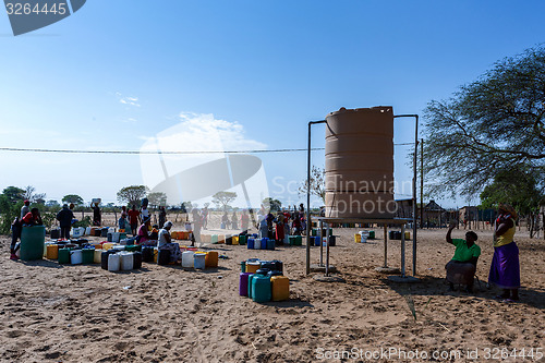Image of Unidentified Namibian woman with child near public tank with dri