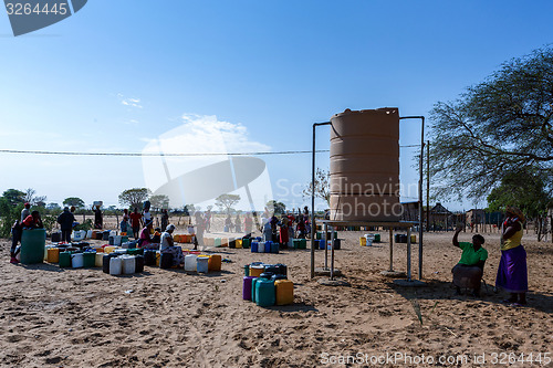 Image of Unidentified Namibian woman with child near public tank with dri