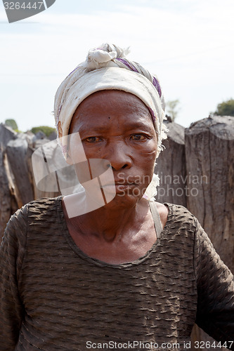 Image of Portrait of old wrinkled woman behind gate of his village