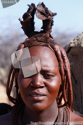 Image of Himba woman with ornaments on the neck in the village