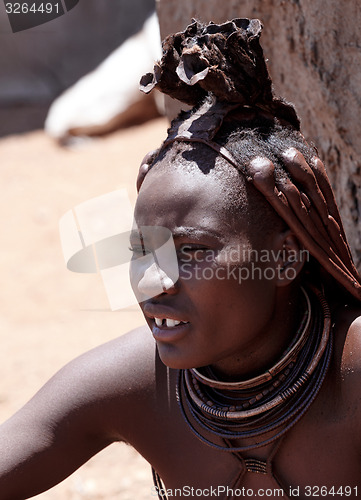 Image of Himba woman with ornaments on the neck in the village