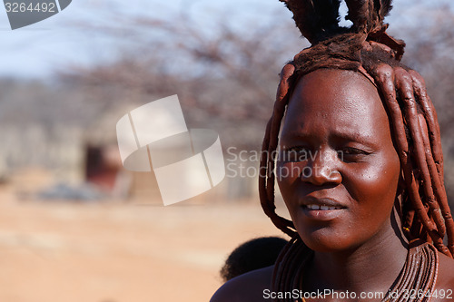 Image of Himba woman with ornaments on the neck in the village