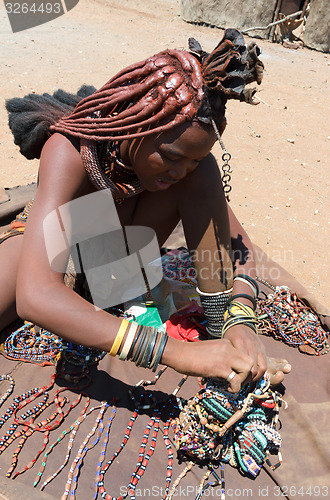 Image of Himba girl with souvenirs for sale in traditional village