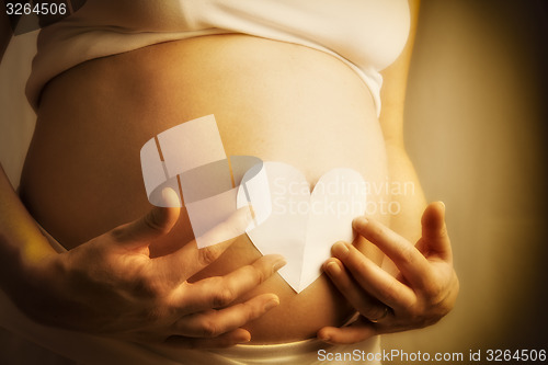 Image of baby bump with paper heart