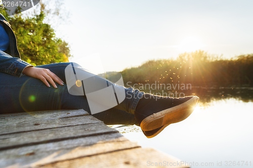 Image of Woman relaxing on jetty