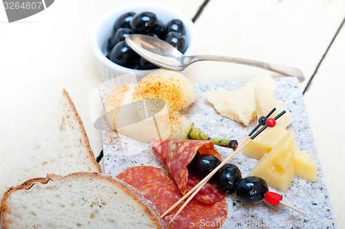 Image of mix cold cut on a stone with fresh pears