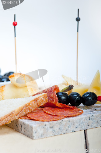 Image of mix cold cut on a stone with fresh pears