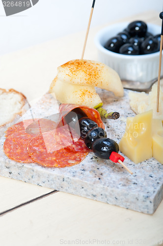 Image of mix cold cut on a stone with fresh pears