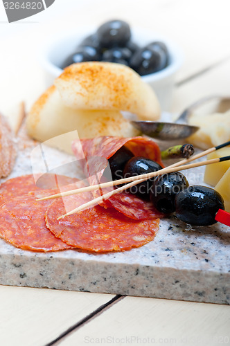 Image of mix cold cut on a stone with fresh pears