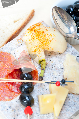 Image of mix cold cut on a stone with fresh pears