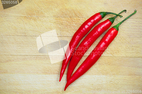 Image of peppers on the wooden background