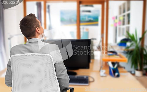 Image of businessman sitting in office chair from back