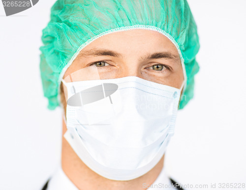Image of surgeon in medical cap and mask
