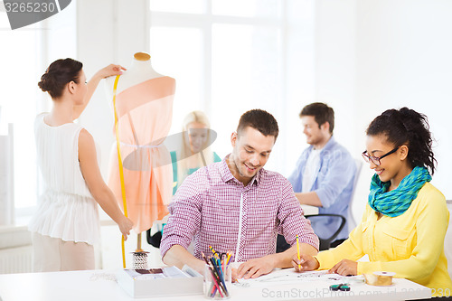 Image of smiling fashion designers working in office