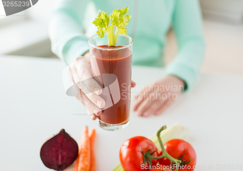 Image of close up of woman hands with juice and vegetables