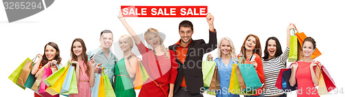 Image of happy people with red sale sign and shopping bags