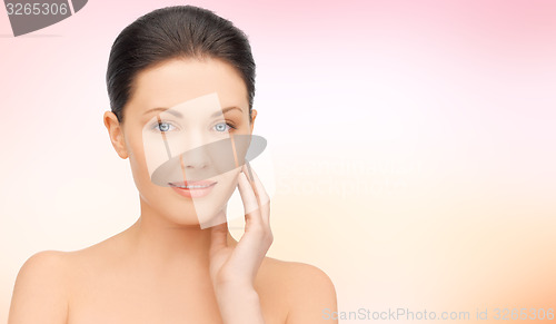 Image of beautiful young woman touching her face
