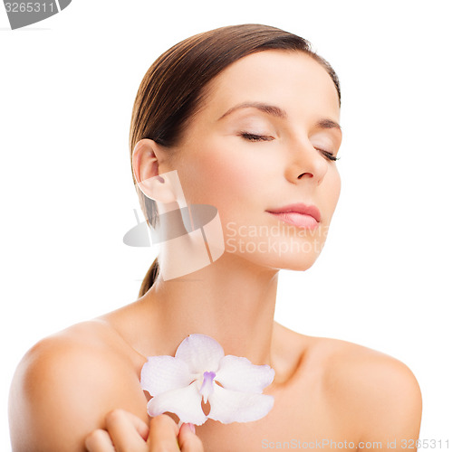 Image of relaxed woman with orhid flower
