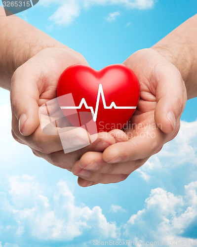 Image of close up of hands holding heart with cardiogram