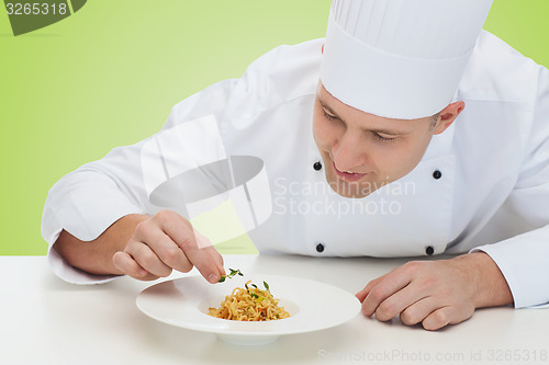 Image of happy male chef cook decorating dish