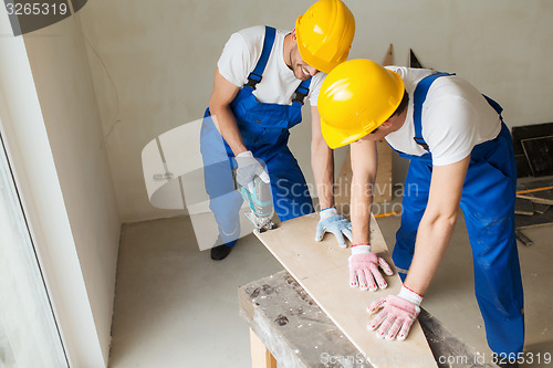 Image of group of builders with tools indoors