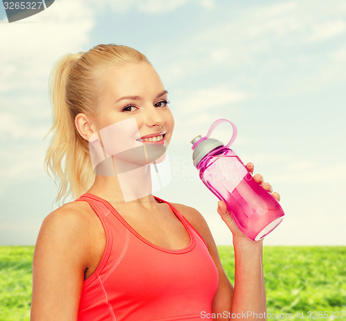 Image of smiling sporty woman with water bottle