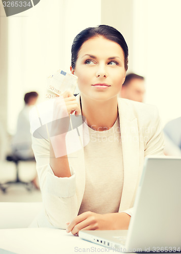 Image of pensive businesswoman with cash money