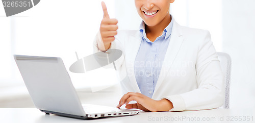 Image of businesswoman with laptop showing thumbs up