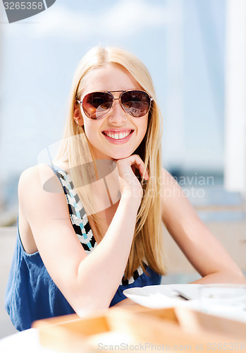 Image of girl in shades in cafe on the beach