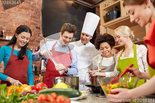 Image of happy friends and chef cook cooking in kitchen