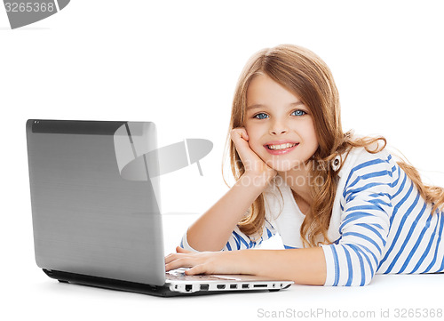 Image of smiling student girl with laptop computer lying