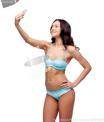 Image of woman in swimsuit taking selfie with smatphone