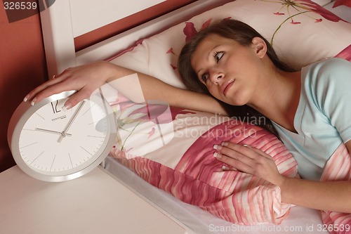 Image of Woman reaching for alarm clock