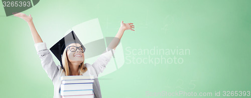 Image of happy student in mortar board cap with books